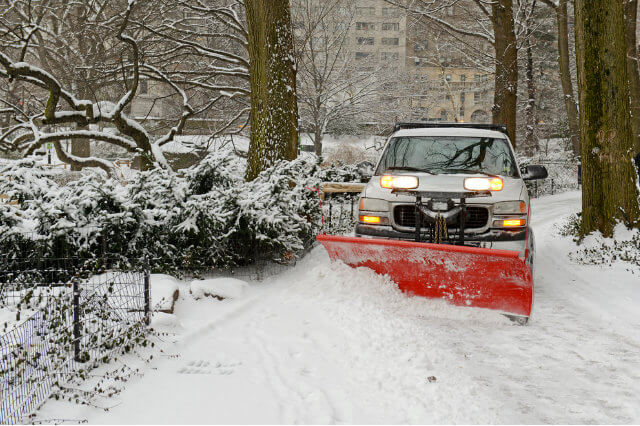 A truck with a snow plow clearing snow.