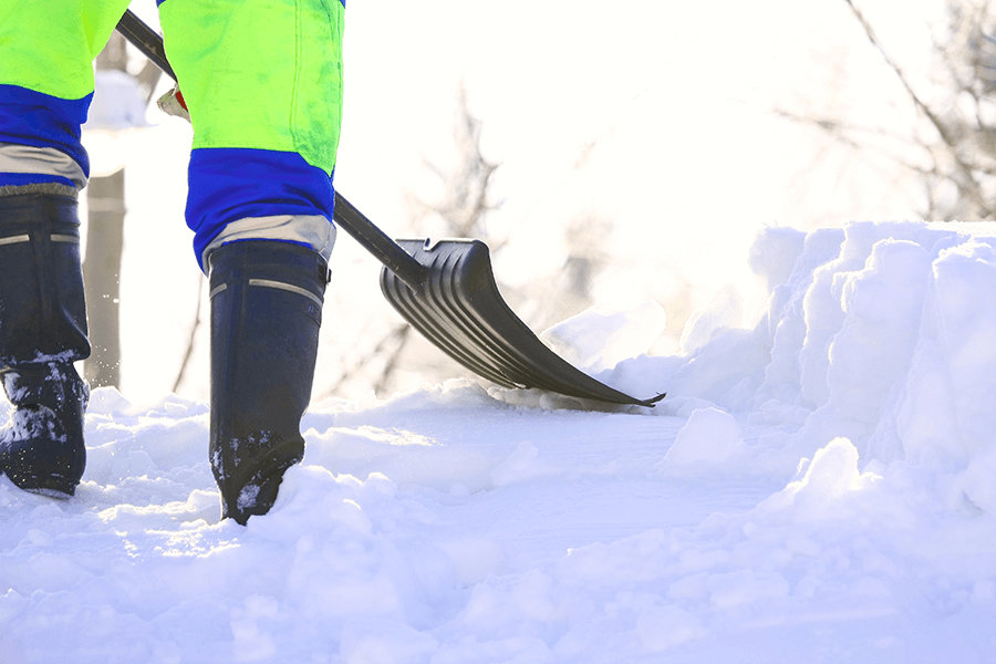 closeup of legs of a person shoveling snow.
