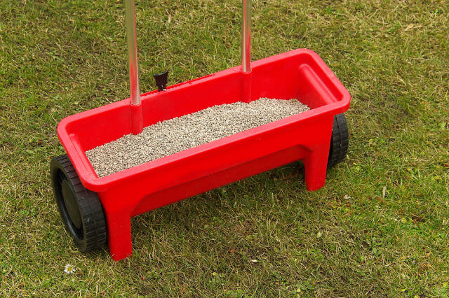 a red lawn fertilizer tool.